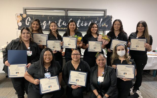 Graduates from a Central Valley Health Network and JVS training program smile and show their certificates